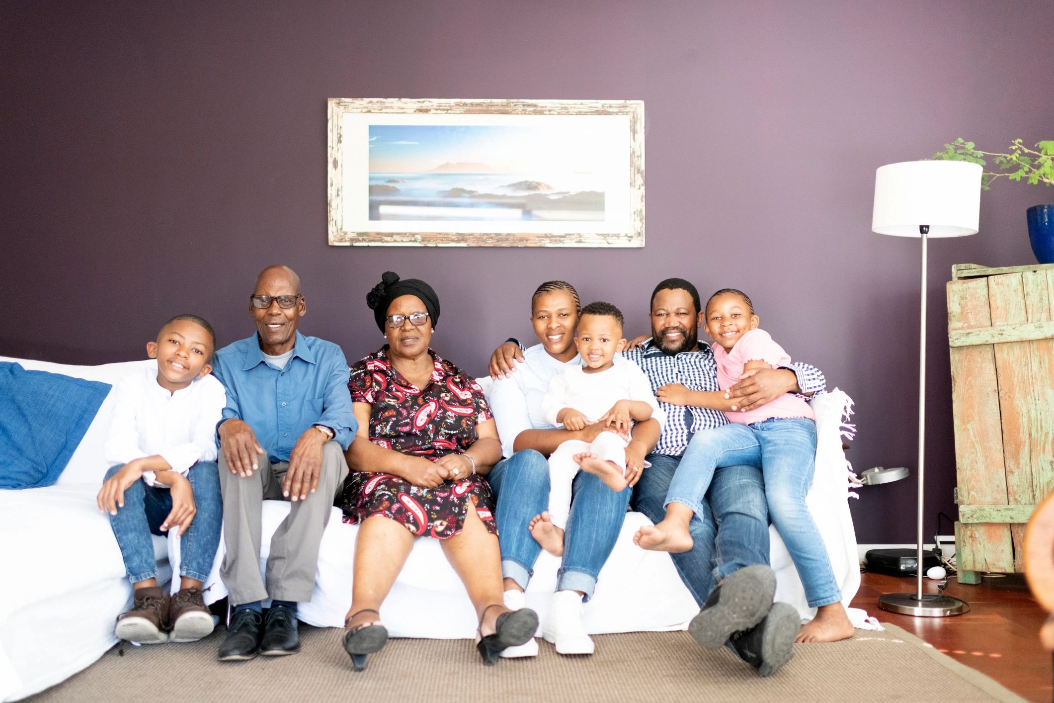 Three generation family portrait sitting together in a living room