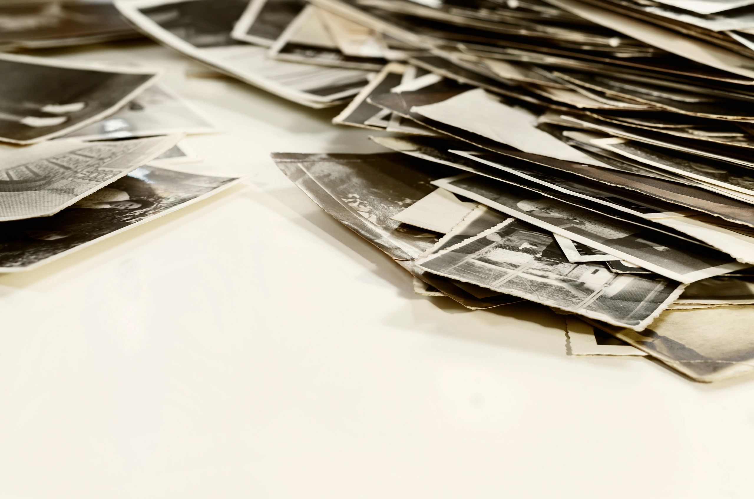 Pile of old family photographs arranged on a table